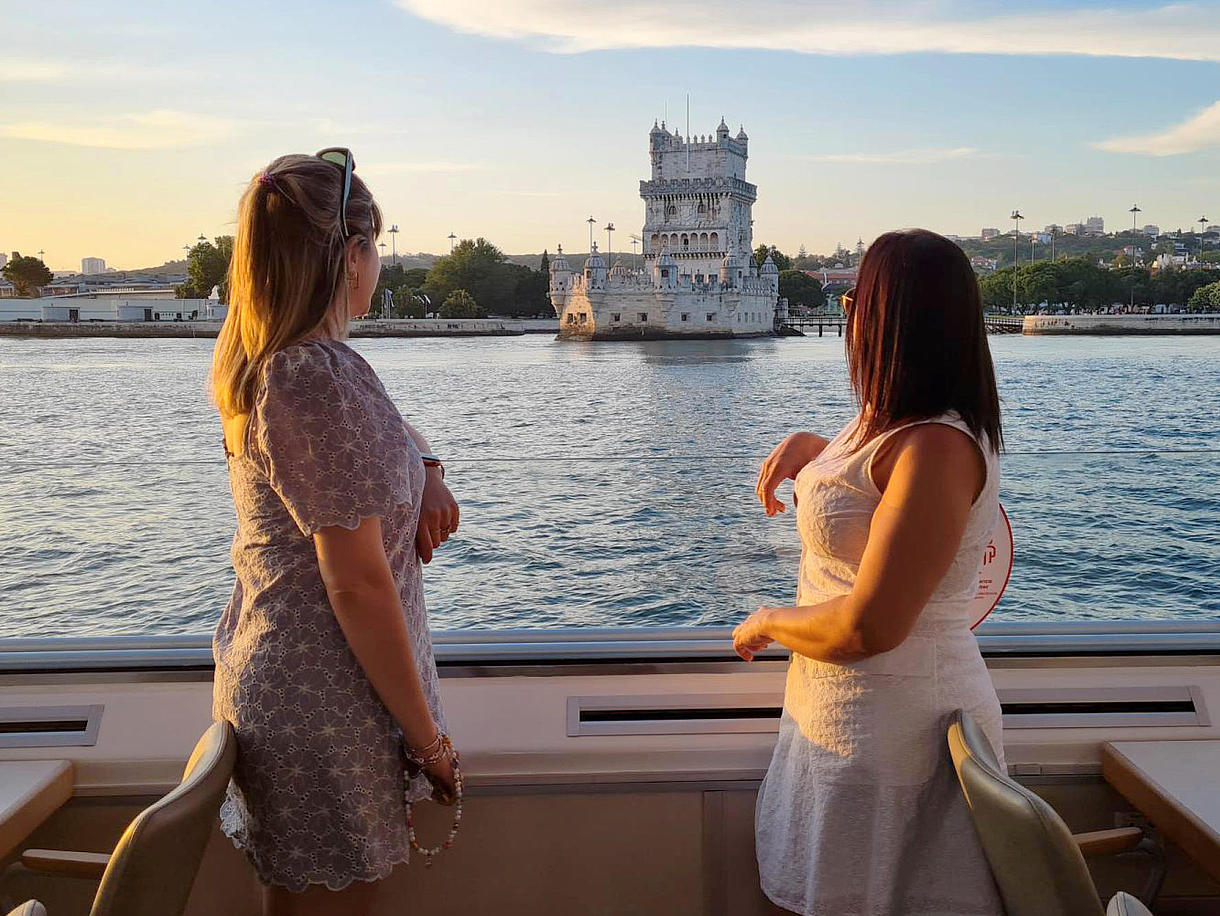 Two woman on the FRS Portugal Sunset Cruise in Lisbon looking at the sights
