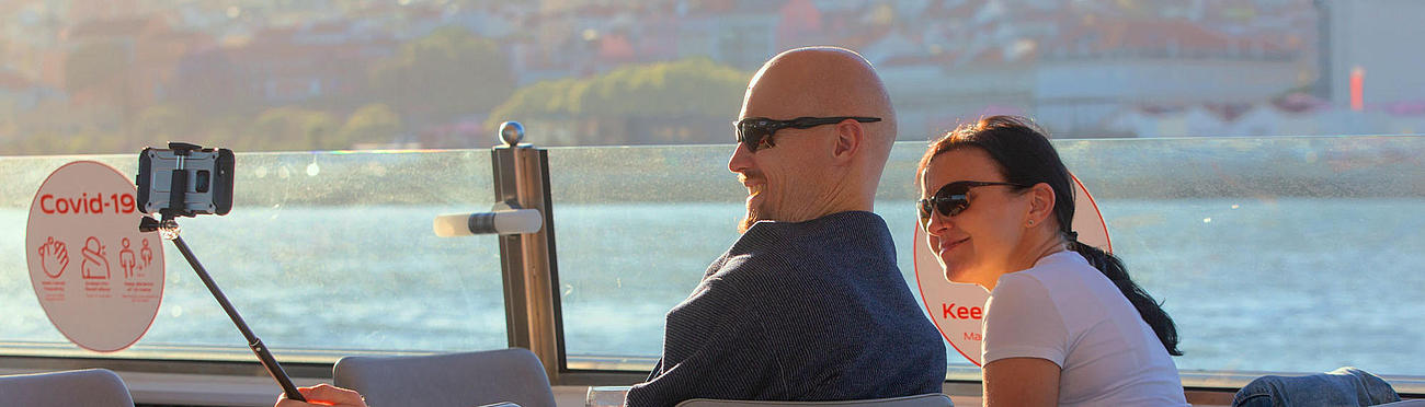 Ein Pärchen macht ein Selfie an Bord des Schiffes während der Rundfahrt auf dem Tejo.
