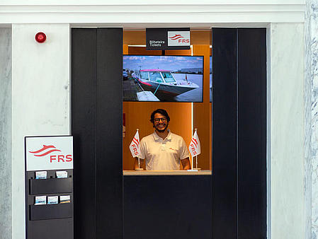 A man is standing at the ticket office.