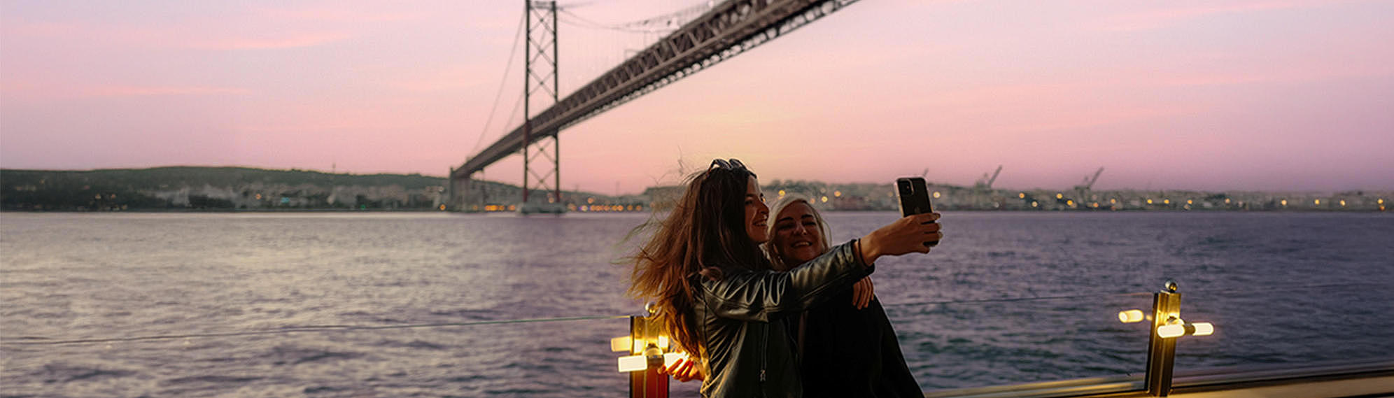 FRS Portugal sunset cruise two woman taking a selfie in front of ponte abril 25