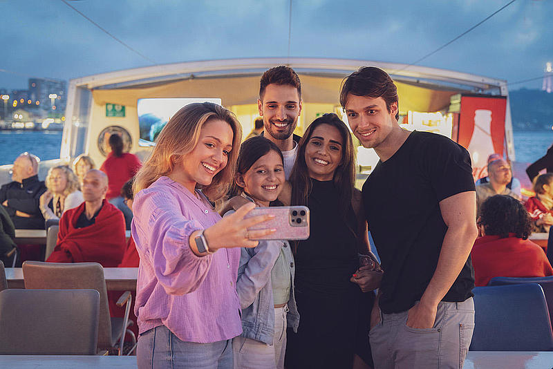 People taking selfies on a river sunset cruse