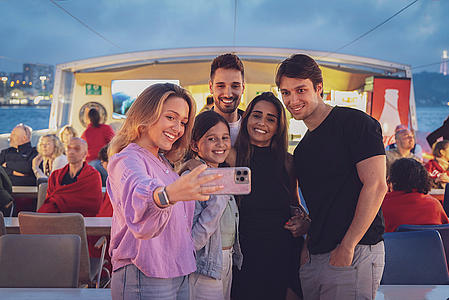People taking selfies on a river sunset cruse