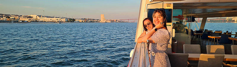 Two woman on a tagus river boat cruise watching sights at the Riverside