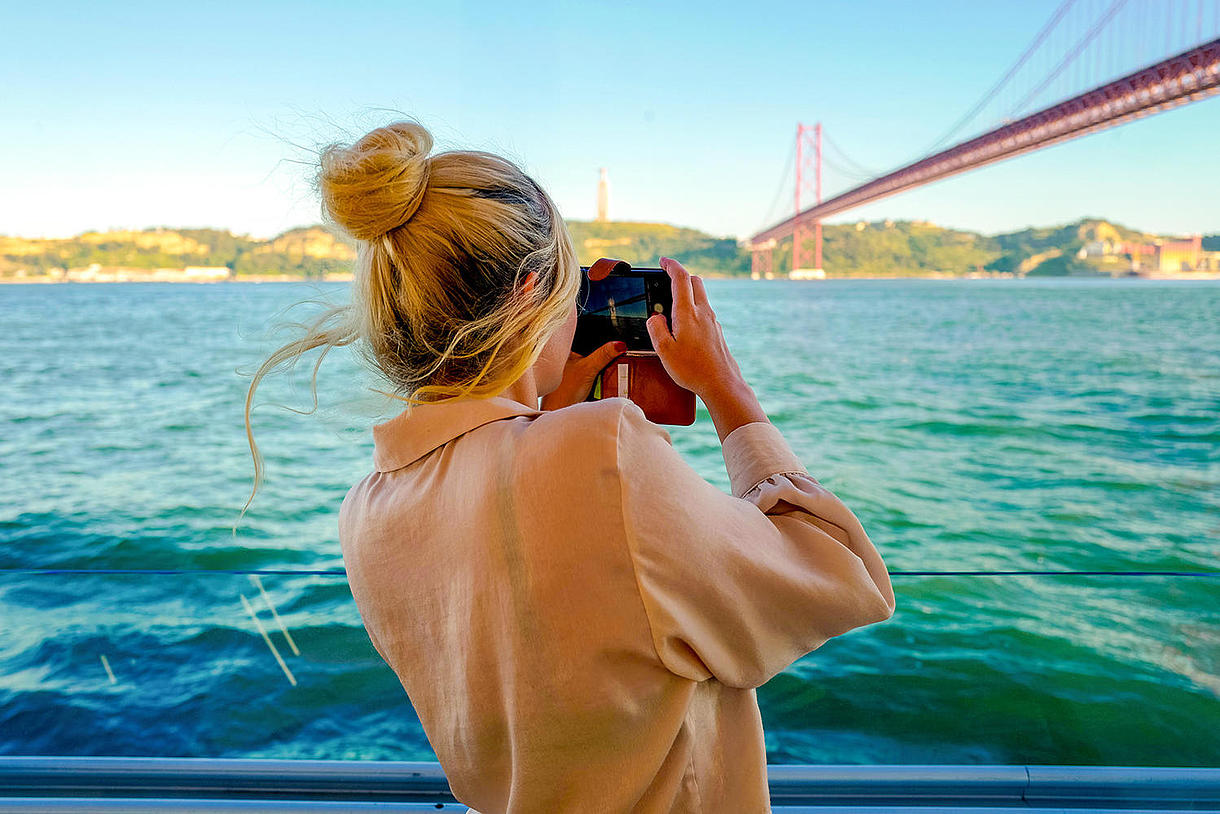 Une femme sur un bateau prend une photo lors de la croisière d'une journée FRS Portugal