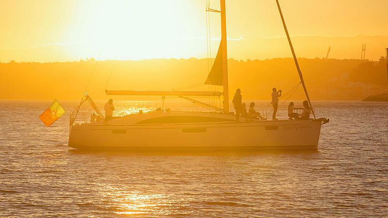 Segelboot im hellen Sonnenlicht auf dem Tejo.