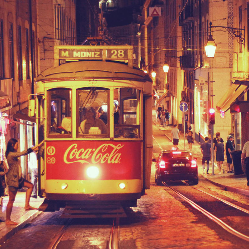 Die Straßenbahn Electrico 28 bei Nacht, wie sie die Distrikte Alfama und Baixa in Lissabon durchkreuzt.
