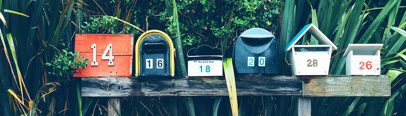 Colourful mailboxes on a bench.