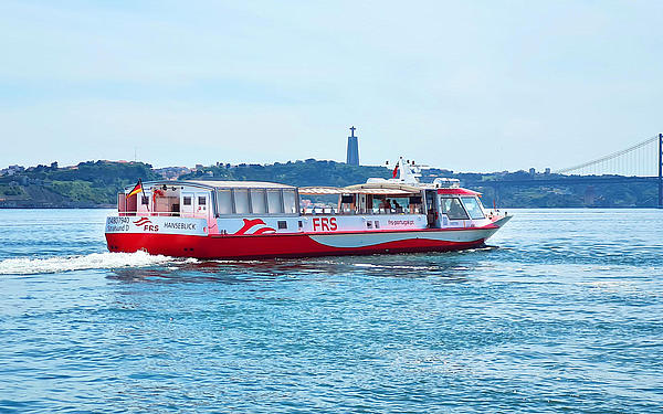 Vessel cruising on the Tagus river, Cristo Rei and the Ponte 25 de Abril in the background.