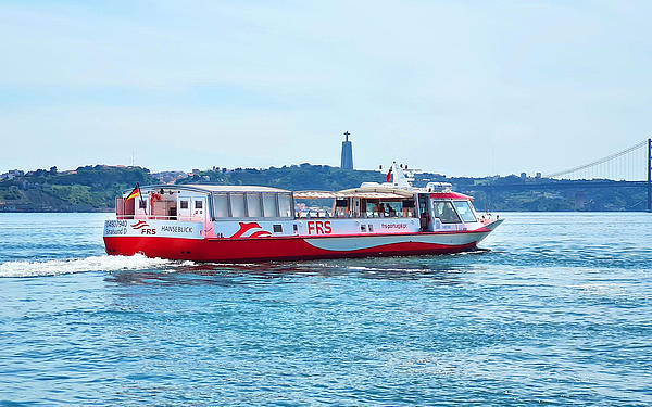 Vessel cruising on the Tagus river, Cristo Rei and the Ponte 25 de Abril in the background.