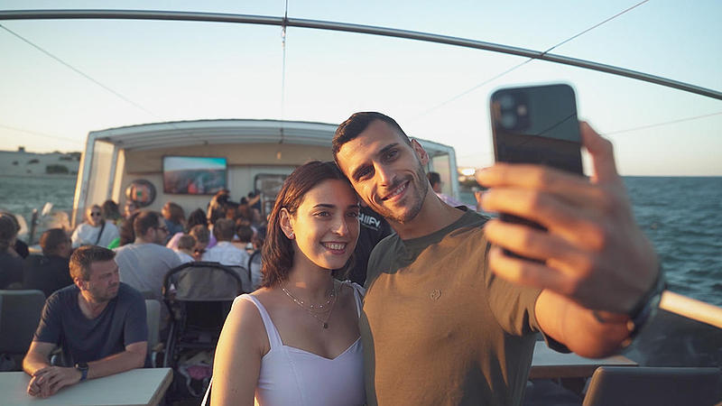 FRS Portugal sunset cruise showing a romantic couple taking selfies on board