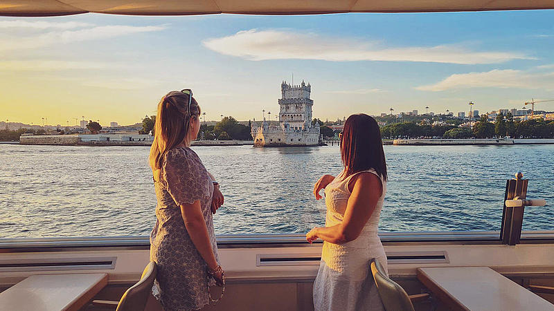 Two women on the FRS Portugal Sunset Cruise in Lisbon looking at the sights
