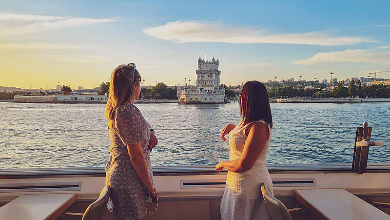 Two women on the FRS Portugal Sunset Cruise in Lisbon looking at the sights