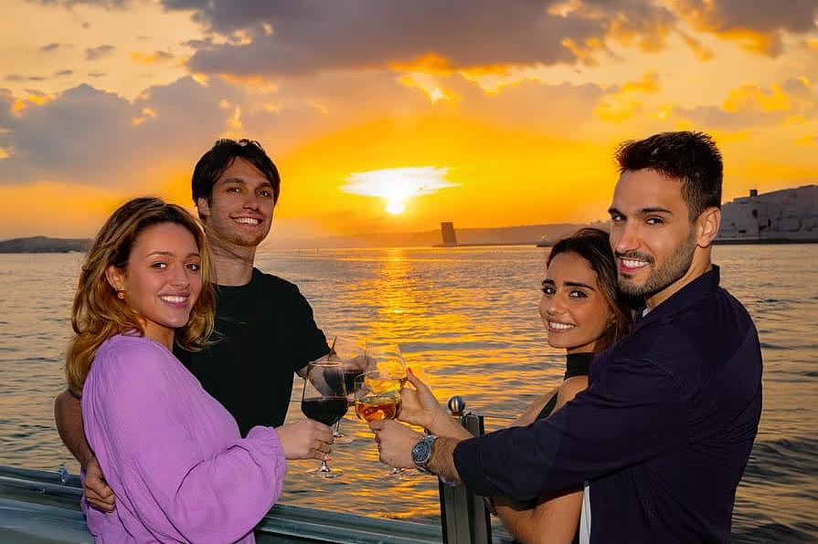 Um grupo de pessoas a desfrutar de um passeio romântico ao pôr-do-sol com o sol a desaparecer no horizonte