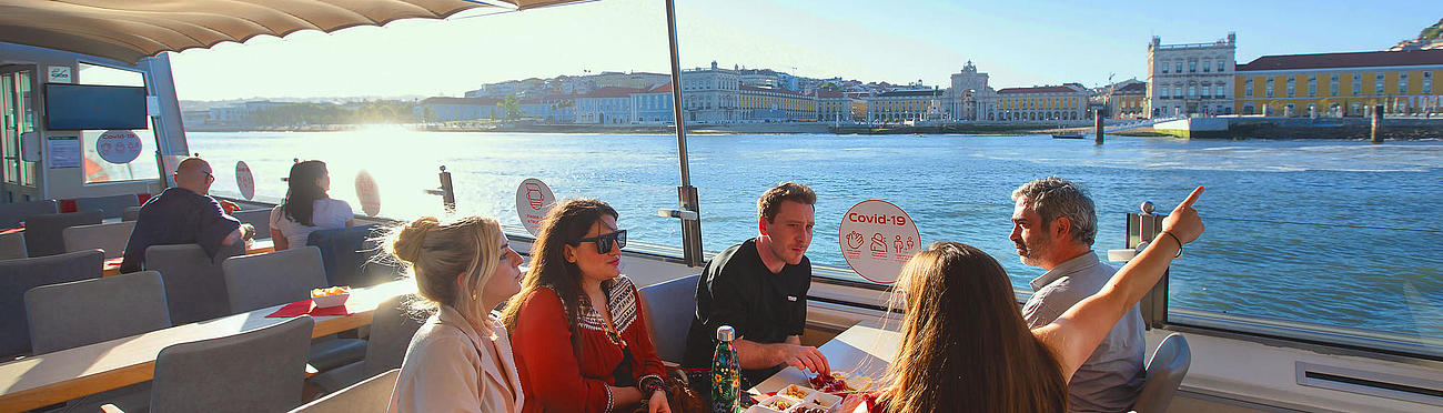 Group of people enjoying snacks and the view during the Sunset Cruise.