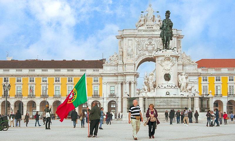 La vue de la Praça do Comércio avec les gens qui se promènent.